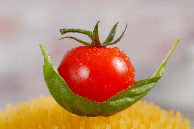 Nahaufnahme einer Kirschtomate auf Teigwaren