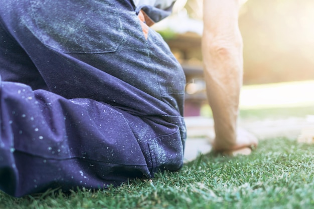 Nahaufnahme einer knienden Person, die im Garten arbeitet