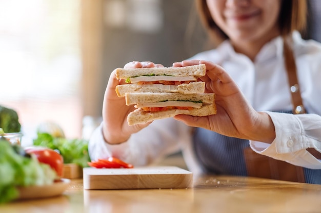 Nahaufnahme einer Köchin, die ein Vollkornbrot in der Küche kocht und zeigt