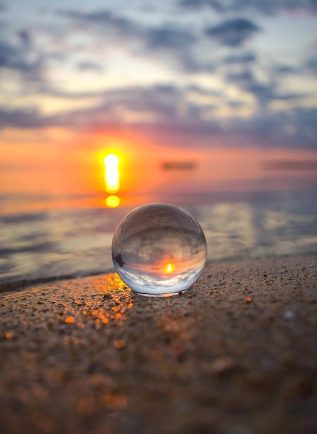 Foto nahaufnahme einer kristallkugel am strand gegen den himmel bei sonnenuntergang