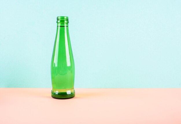 Foto nahaufnahme einer leeren flasche auf dem tisch vor blauem hintergrund