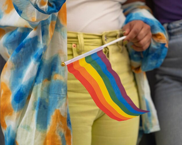 Foto nahaufnahme einer lesbischen frau, die eine regenbogenflagge für die homosexuellenparade hält