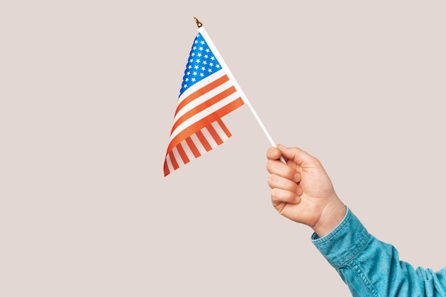 Nahaufnahme einer männlichen Hand, die die Flagge der Vereinigten Staaten von Amerika hält