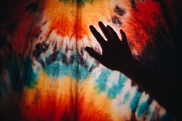 Foto nahaufnahme einer menschlichen hand gegen ein farbenfrohes muster