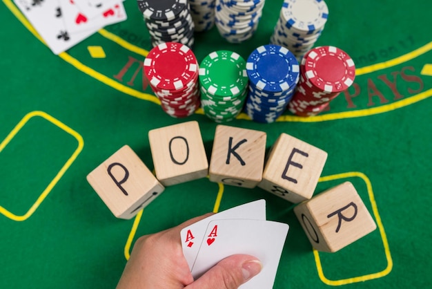 Nahaufnahme einer menschlichen Hand mit Spielkarten auf einem grünen Casino-Tisch Gamble Poker-Konzept