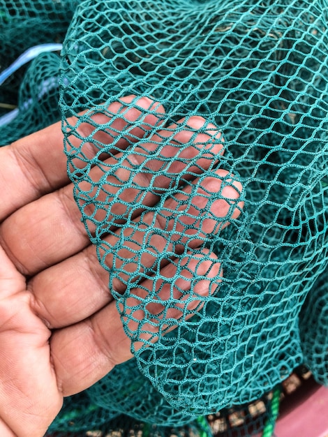 Foto nahaufnahme einer menschlichen hand und eines fischernetzes