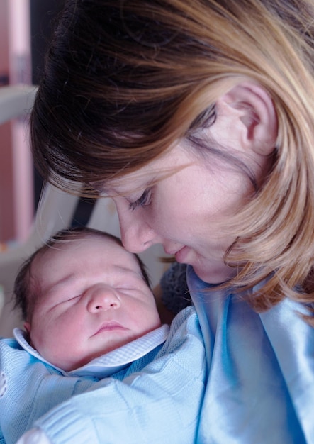 Foto nahaufnahme einer mutter, die auf einen schlafenden jungen schaut