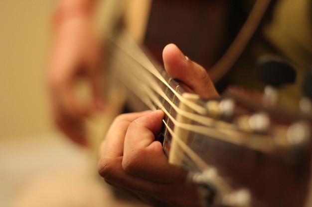 Foto nahaufnahme einer person, die akustische gitarre spielt