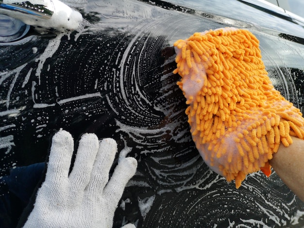 Foto nahaufnahme einer person, die das auto reinigt
