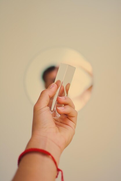 Foto nahaufnahme einer person, die ein glas hält, mit reflexion