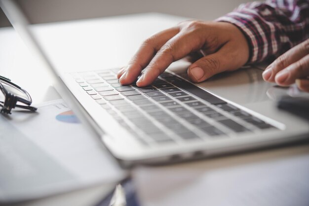 Foto nahaufnahme einer person, die einen laptop auf dem tisch benutzt