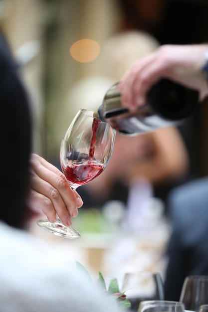 Nahaufnahme einer Person, die Wein gießt