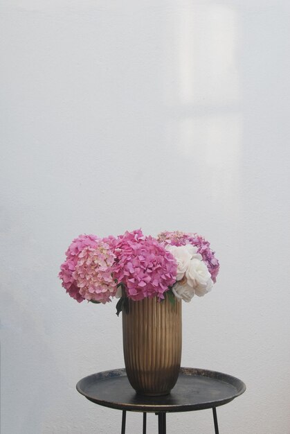 Foto nahaufnahme einer rosa blumenvase auf dem tisch gegen die wand