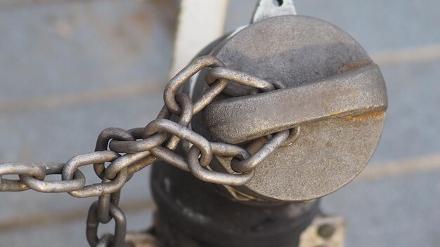 Foto nahaufnahme einer rostigen kette, die an metall hängt