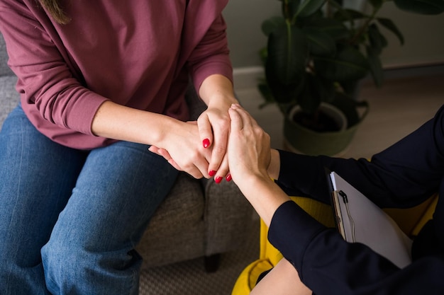 Nahaufnahme einer Ärztin Psychologin hält die Hand des Patienten zur Unterstützung. Professionelle psychologische Hilfe.