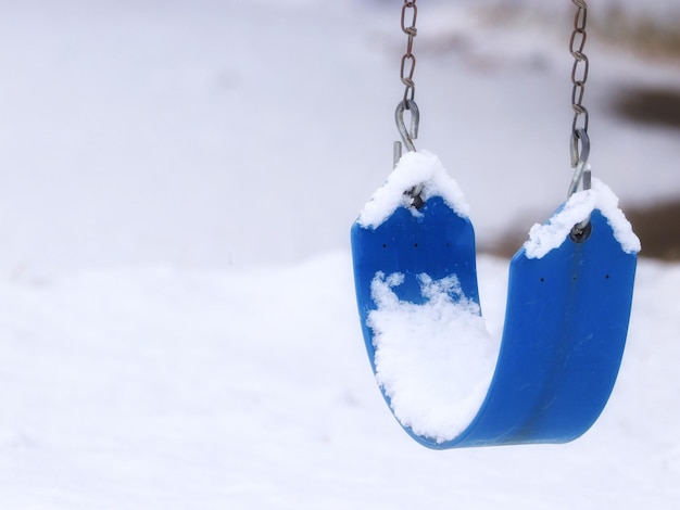 Nahaufnahme einer Schaukel, die im Schnee hängt