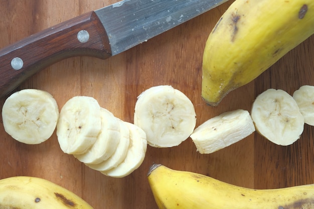 Nahaufnahme einer Scheibe frischer Banane und eines Küchenmessers auf dem Tisch