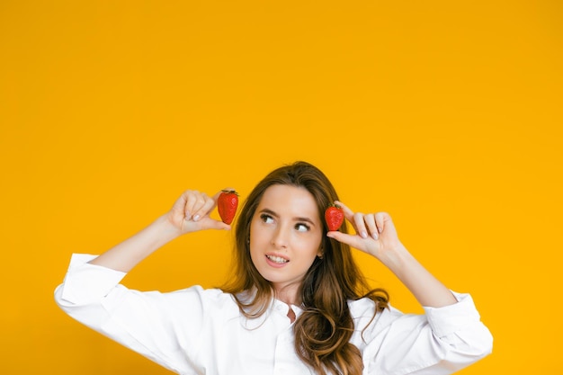 Nahaufnahme einer sexy Frau, die frische Erdbeere isst Sexuelle Lippen roter Lippenstift Gesundes Ernährungskonzept