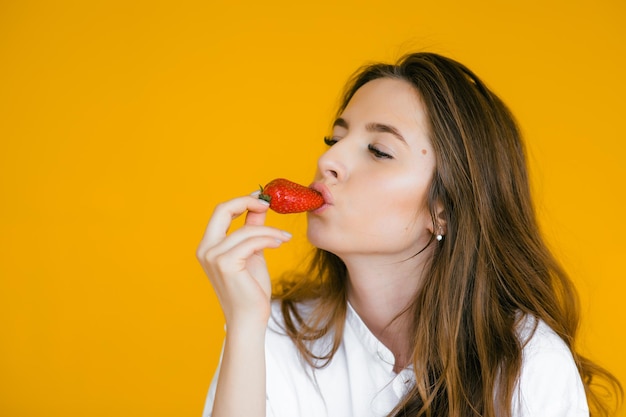 Foto nahaufnahme einer sexy frau, die frische erdbeere isst sexuelle lippen roter lippenstift gesundes ernährungskonzept