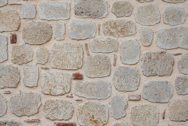 Nahaufnahme einer straßenbraunen antiken Wand mit erhabenen Details. Fliesenmuster