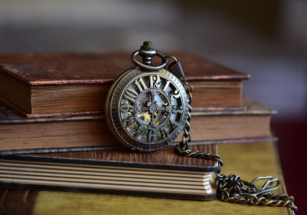 Nahaufnahme einer Taschenuhr auf Büchern am Tisch