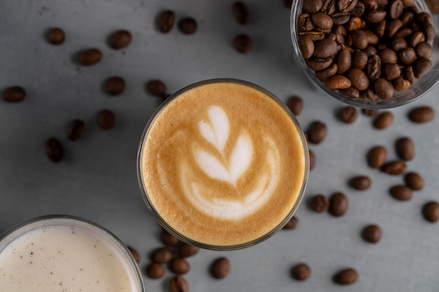 Nahaufnahme einer Tasse Latte mit BlumenschaummilchKaffeebohnenDraufsicht