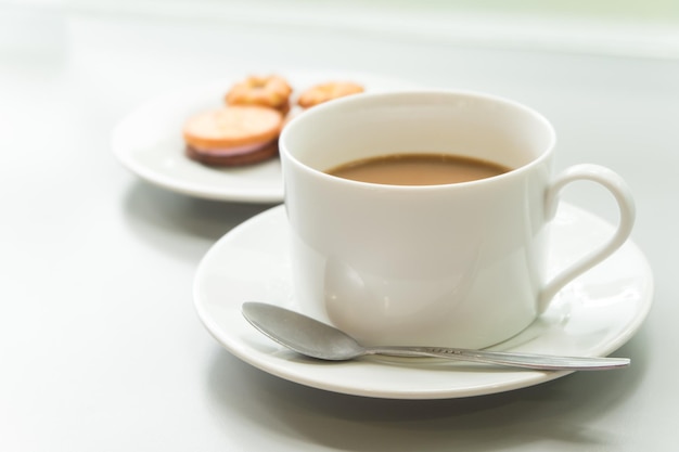 Nahaufnahme einer Teetasse mit Kekse im Hintergrund