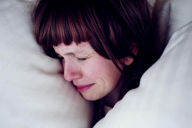Nahaufnahme einer traurigen Frau im Bett