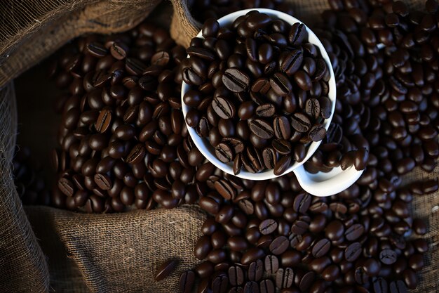 Nahaufnahme einer überquellenden Tasse Kaffee mit frischen Bohnen, die dem von KI generierten Kaffeegeschmack einen Hauch von Tradition verleiht