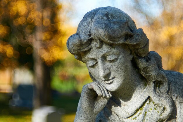 Foto nahaufnahme einer weiblichen statue auf dem friedhof im herbst