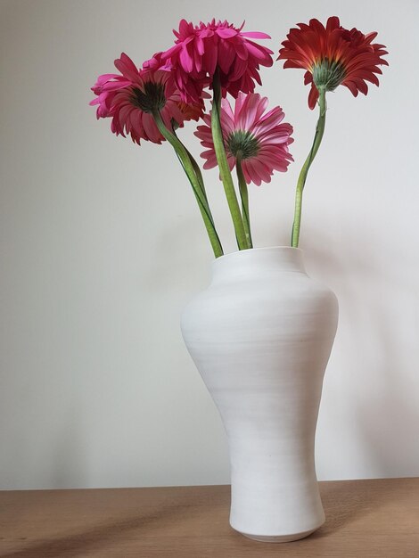 Foto nahaufnahme einer weißen blumenvase auf dem tisch an der wand