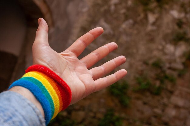 Nahaufnahme einer weit geöffneten Handfläche mit einem Regenbogenband