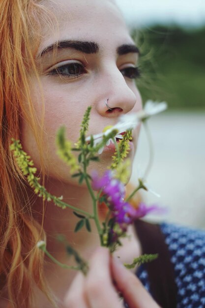 Nahaufnahme einer wunderschönen jungen Frau mit einer Blume