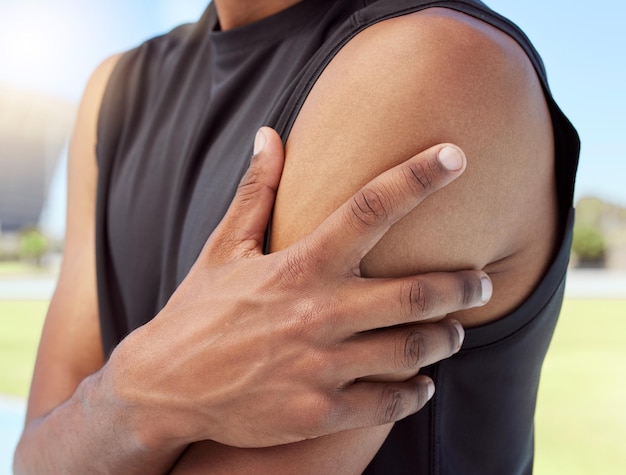 Nahaufnahme eines afroamerikanischen Sportlers, der während des Trainings unter Schulterschmerzen leidet Heranzoomen auf einen unbekannten schwarzen Mann, der einen wunden Arm hält und reibt, wobei die Muskeln überlastet werden und Verspannungen verursachen