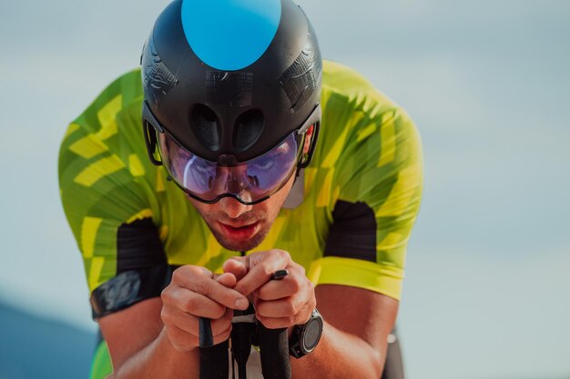 Foto nahaufnahme eines aktiven triathleten in sportbekleidung und mit schutzhelm beim fahrradfahren. selektiver fokus.