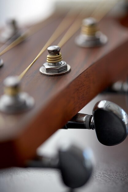 Nahaufnahme eines akustischen Gitarrenkopfes mit Klammern