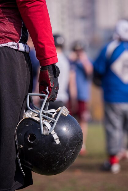 Nahaufnahme eines American-Football-Spielers mit schwarzem Helm auf dem Feld