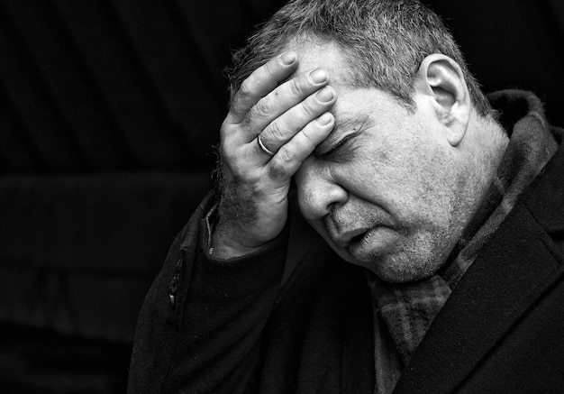 Nahaufnahme eines angespannten reifen Mannes mit Kopf in der Hand