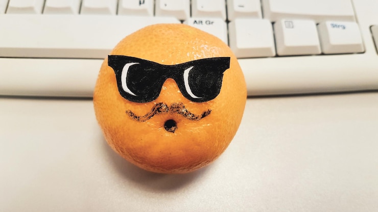 Foto nahaufnahme eines anthropomorphen gesichts auf einer orangenfrucht am desktop