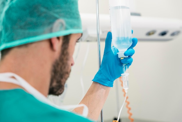 Nahaufnahme eines Arztes, der im Krankenhaus einen Tropf intravenös hält