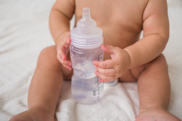 Nahaufnahme eines Babys, das eine Wasserflasche hält
