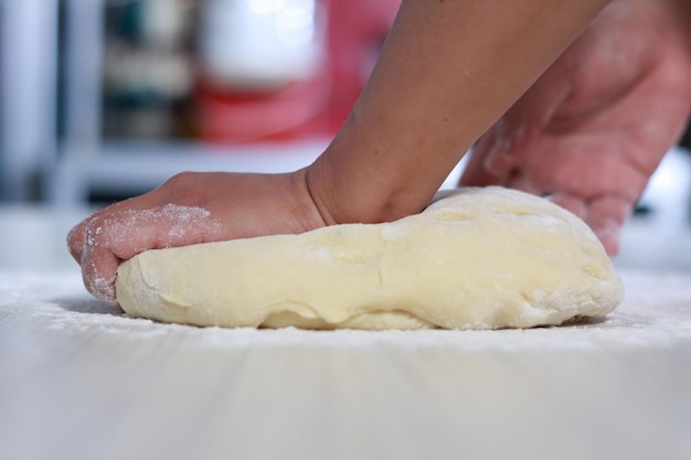 Nahaufnahme eines Bäckereichchefs, der Brotteig in der Küche herstellt