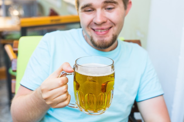 Nahaufnahme eines bärtigen Mannes, der Bier aus einem Bierkrug trinkt.