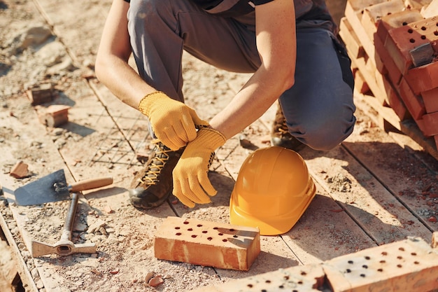 Nahaufnahme eines Bauarbeiters in Uniform und Sicherheitsausrüstung, der sich auf den Job vorbereitet