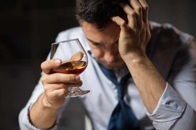 Foto nahaufnahme eines betrunkenen mannes, der nachts alkohol trinkt