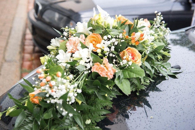 Foto nahaufnahme eines bouquets auf einem auto bei einer hochzeit