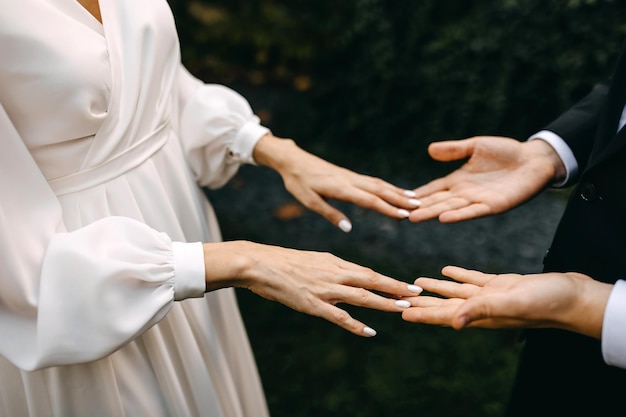 Foto nahaufnahme eines brautpaares, das sich an den händen hält und die finger berührt