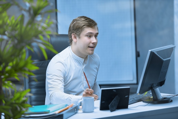 Nahaufnahme eines Büroangestellten, der an einem Schreibtisch sitzt und sich auf die Arbeit konzentriert