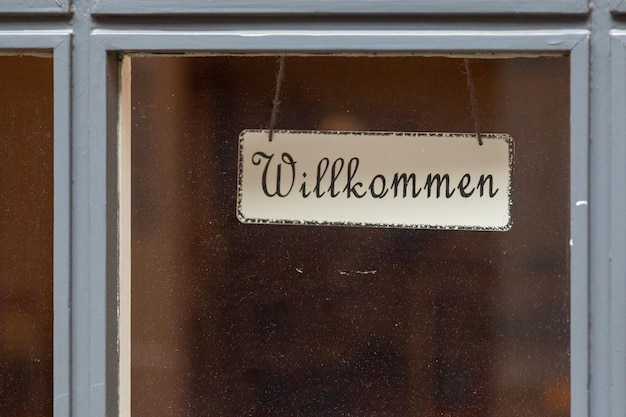 Nahaufnahme eines deutschen Willkommensschildes im Fenster