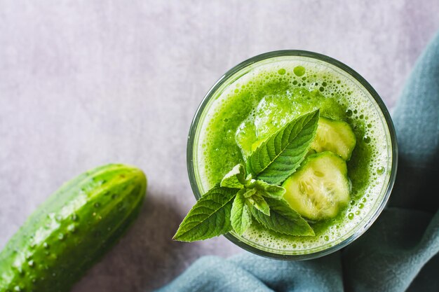 Nahaufnahme eines erfrischenden Gurken-Minz-Smoothies in einem Glas auf der Tischplatte